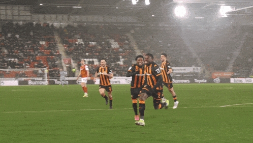 a group of soccer players on a field with a sign that says kcm on it