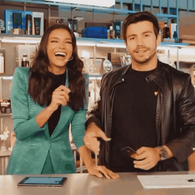 a man and a woman are standing next to each other smiling