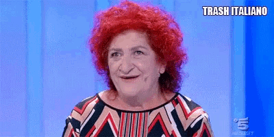 a woman with red hair is making a funny face on a blue background .