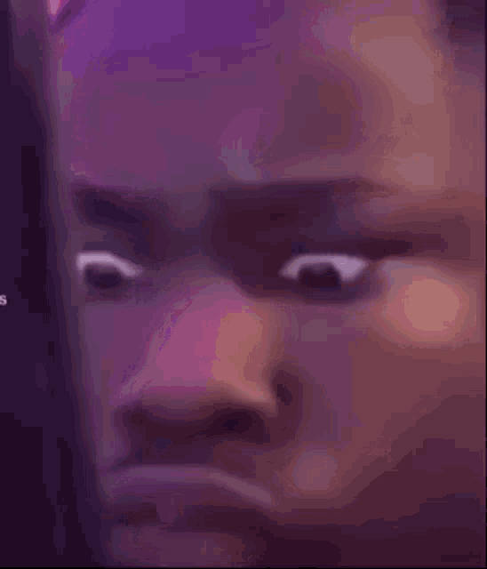 a close up of a man 's face with a purple background and a purple light behind him .