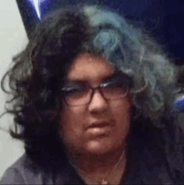a close up of a person wearing glasses and a wig with blue hair .