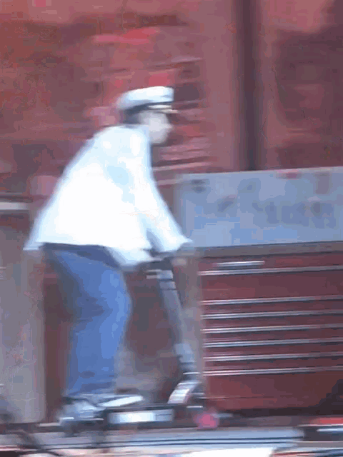 a blurry image of a man riding a scooter