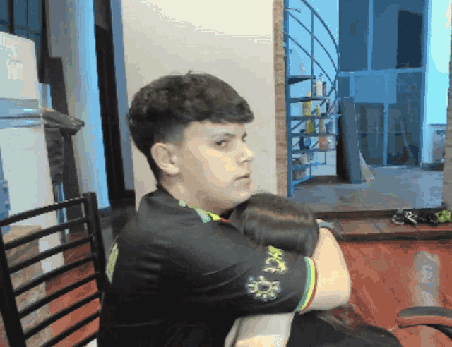 a man sitting in a chair with a black shirt that says ' nct ' on it