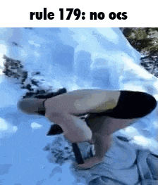 a man without a shirt is kneeling in the snow with a hammer .