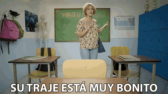 a woman stands in front of a chalkboard in a classroom with the words su traje esta muy bonito below her