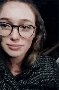 a close up of a woman wearing glasses and a polka dot shirt .