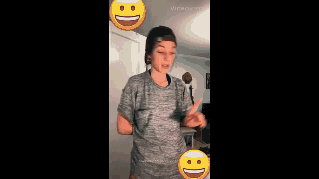 a girl wearing a hat and a gray shirt is dancing with smiley faces around her ..
