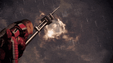 a man in a red suit is holding a spear with the letter t on it