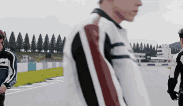 a man in a striped jacket stands on a track