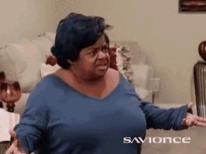 a woman in a blue shirt is sitting on a couch in a living room with the words savonce on the bottom