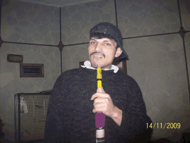 a man is holding a bottle with the date 14/11/2009 on it