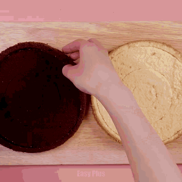 a person is cutting a cake on a cutting board that says easy plus on it
