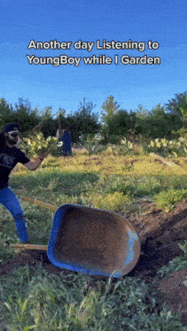 a man is pushing a wheelbarrow in a field with the caption another day listening to youngboy while i garden