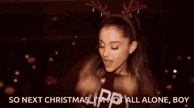 ariana grande is wearing a reindeer headband and a maroon sweater