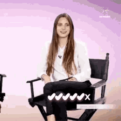 a woman is sitting in a director 's chair .