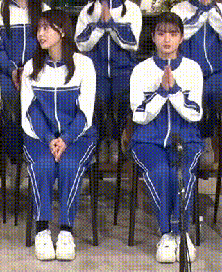 a group of girls are sitting in chairs with their hands folded .