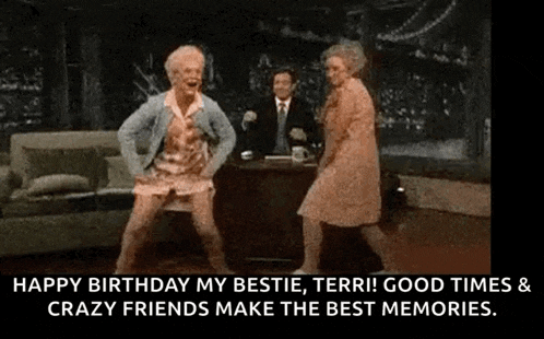 two older women are dancing in a living room with a man sitting at a table .