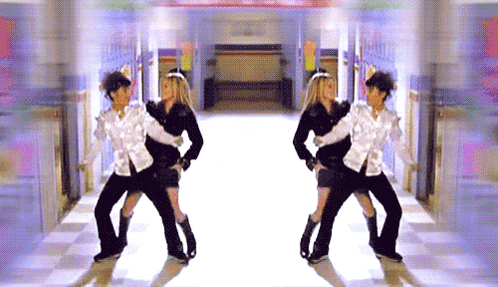 a man and a woman are dancing in a hallway in front of a sign that says ' i love you '