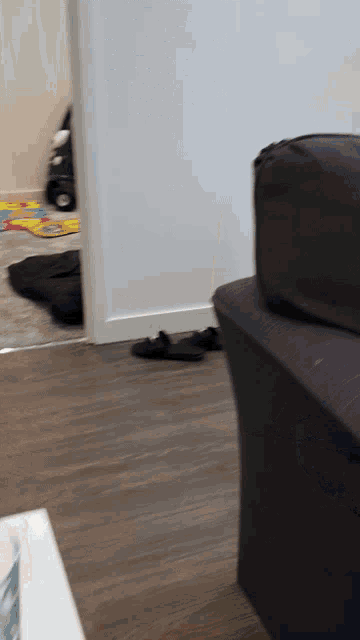 a couch in a living room with a doorway leading to a play area