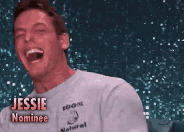 a man wearing a jessie nominee shirt is laughing with his eyes closed