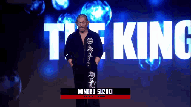 a man stands in front of a large screen that says the king