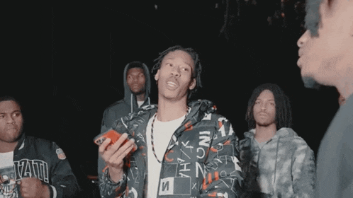 a man wearing a jacket that says ' armani ' on it is talking on a cell phone