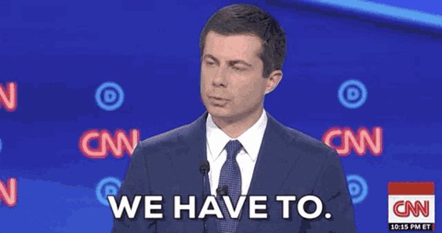 a man in a suit and tie says we have to in front of a cnn logo