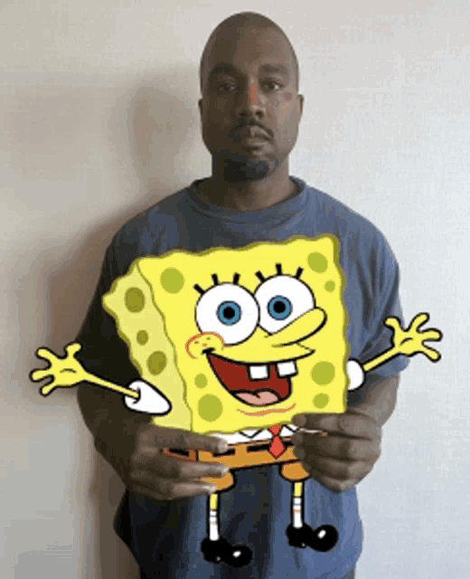 a man in a blue shirt is holding a cartoon of spongebob squarepants