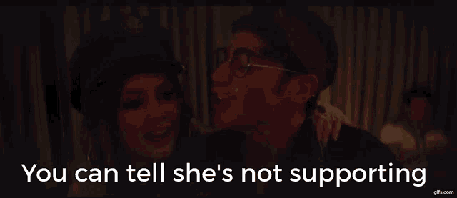 a man and woman are hugging with the words " you can tell she 's not supporting " on the bottom