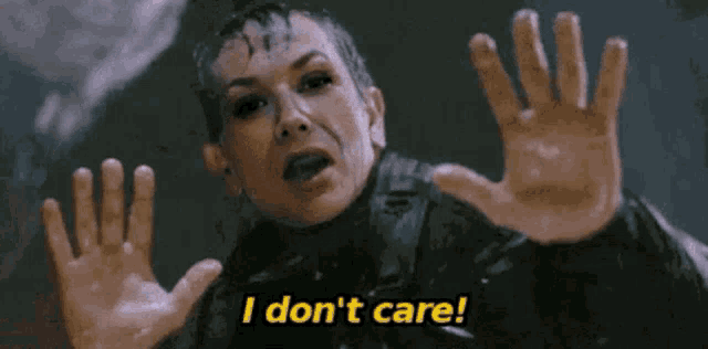 a woman is making a funny face and saying `` i don 't care '' with her hands .
