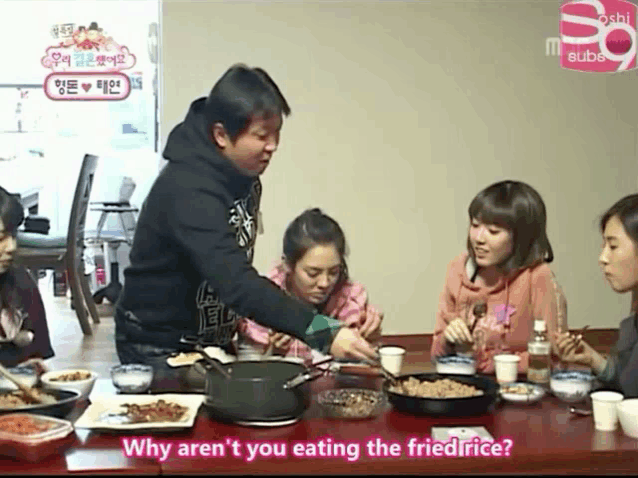 a group of people sitting at a table with a sign that says sushi