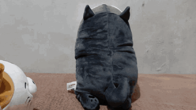 a stuffed cat with a tag on it that says ' miniso ' on it