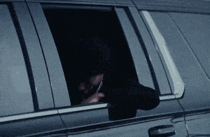 a man is looking out of a car window while talking on a cell phone