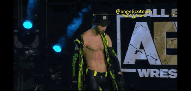 a wrestler is walking through a tunnel with a green light behind him .