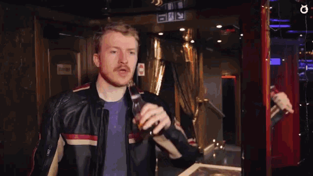 a man in a leather jacket drinking a beer
