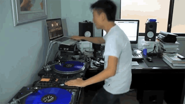 a man is playing a record on a turntable with a blue record on it that says ' a ' on it