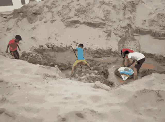 a group of children are playing in the sand and one of them is holding a diamond kite
