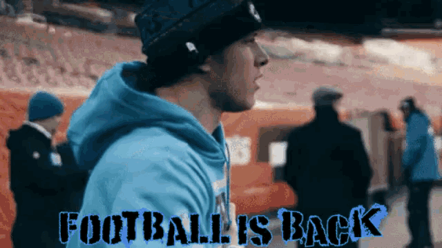 a man in a blue hoodie with the words football is back on the bottom