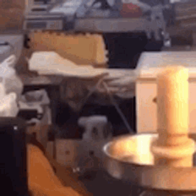 a person is standing in front of a machine in a kitchen with a candle in a bowl .