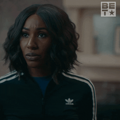 a woman in a black adidas jacket is asking really