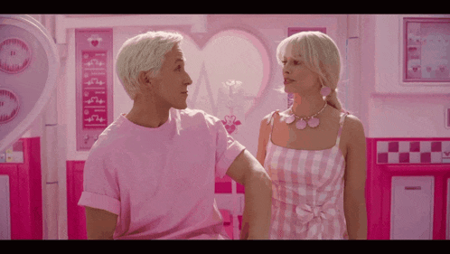a man in a pink shirt and a woman in a pink dress are standing next to each other