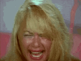 a close up of a woman 's face with tears running down her face