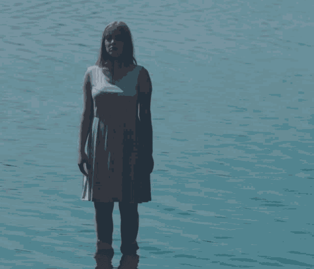 a woman in a dress is standing in the water