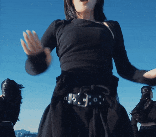 a woman in a black dress has a belt with holes in it