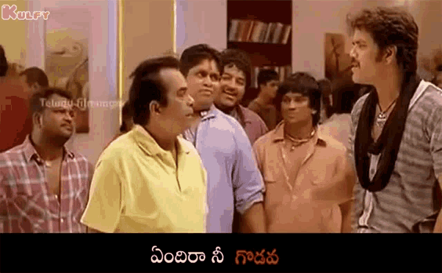 a group of men are standing next to each other in a room and talking .