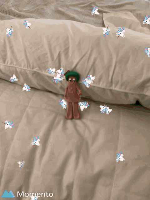 a gingerbread man with a green hat is laying on a bed with unicorns around him