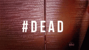 a close up of a person standing in front of a door with the word dead written on it .