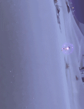 a person standing in the snow with a purple light coming out of it