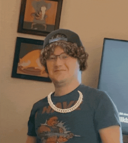 a man wearing a t-shirt that says he man smiles for the camera