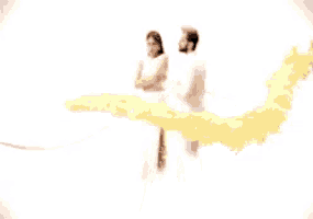 a man and a woman are standing next to each other in front of a yellow smoke coming out of them .